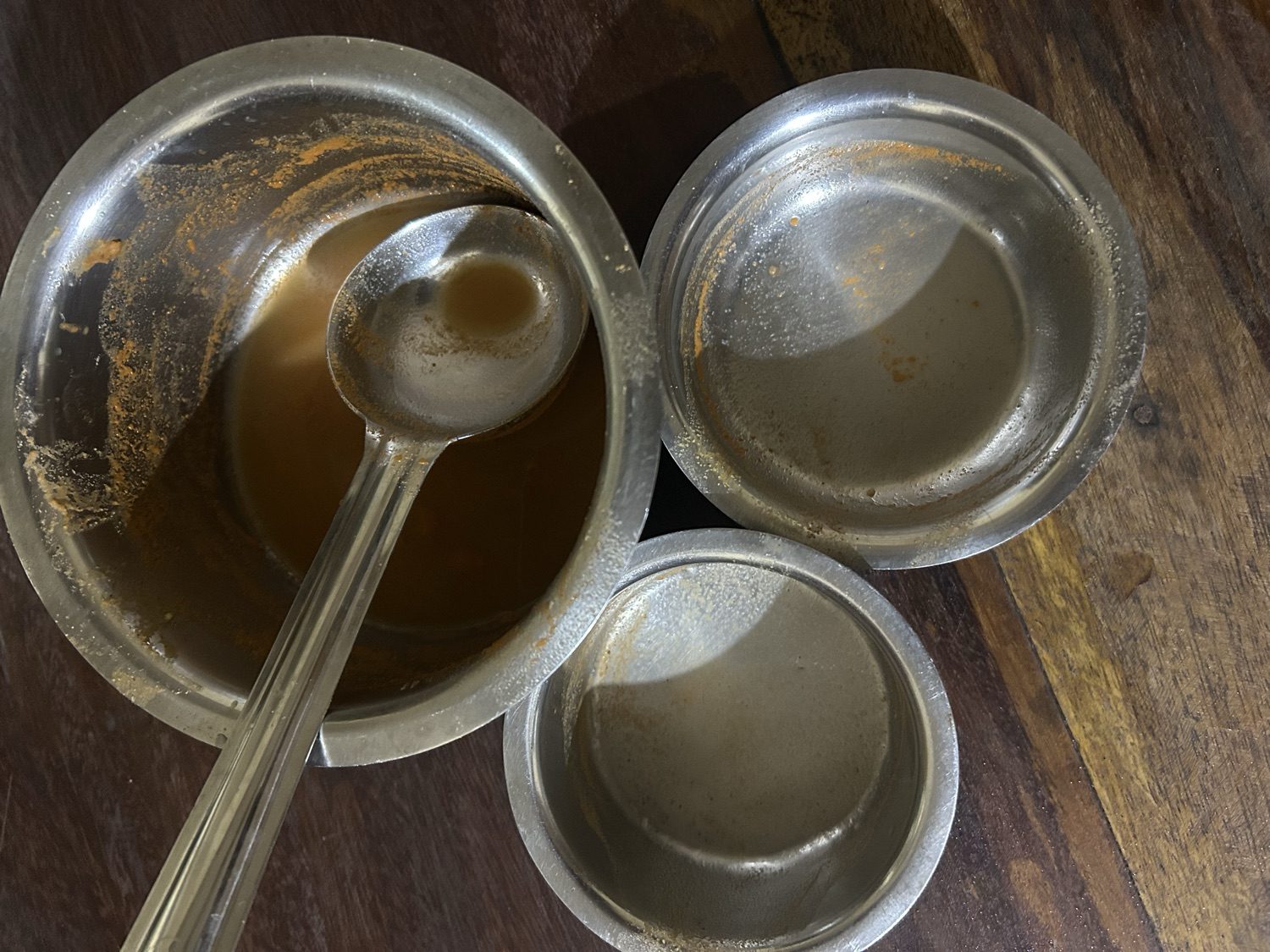 The emptied steel cups and the kashaya bowl after the Aati Amavasya ritual drink